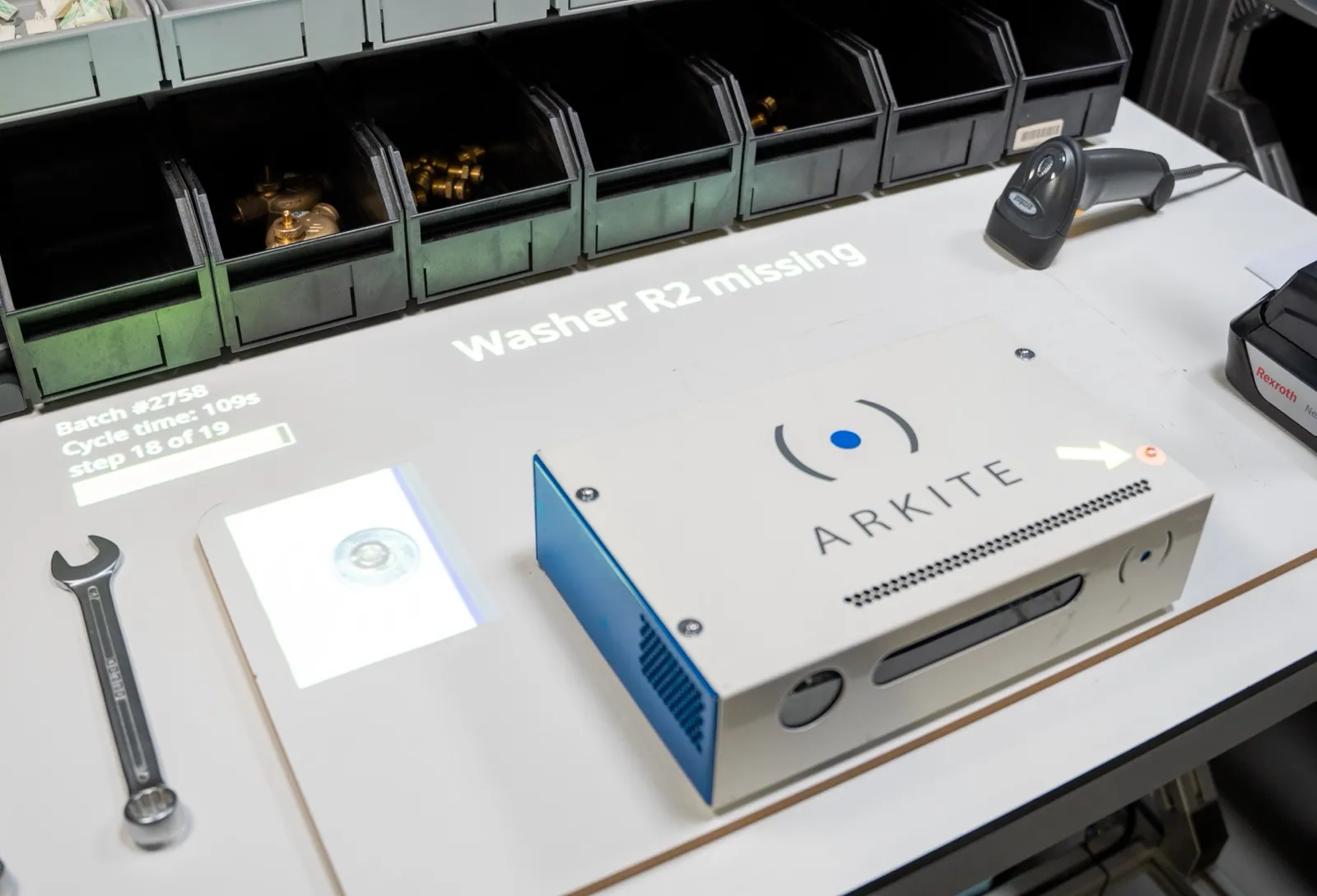 Puesto de trabajo Arkite VISION que proyecta el mensaje Washer R2 missing junto al producto, con una flecha que señala la arandela que falta