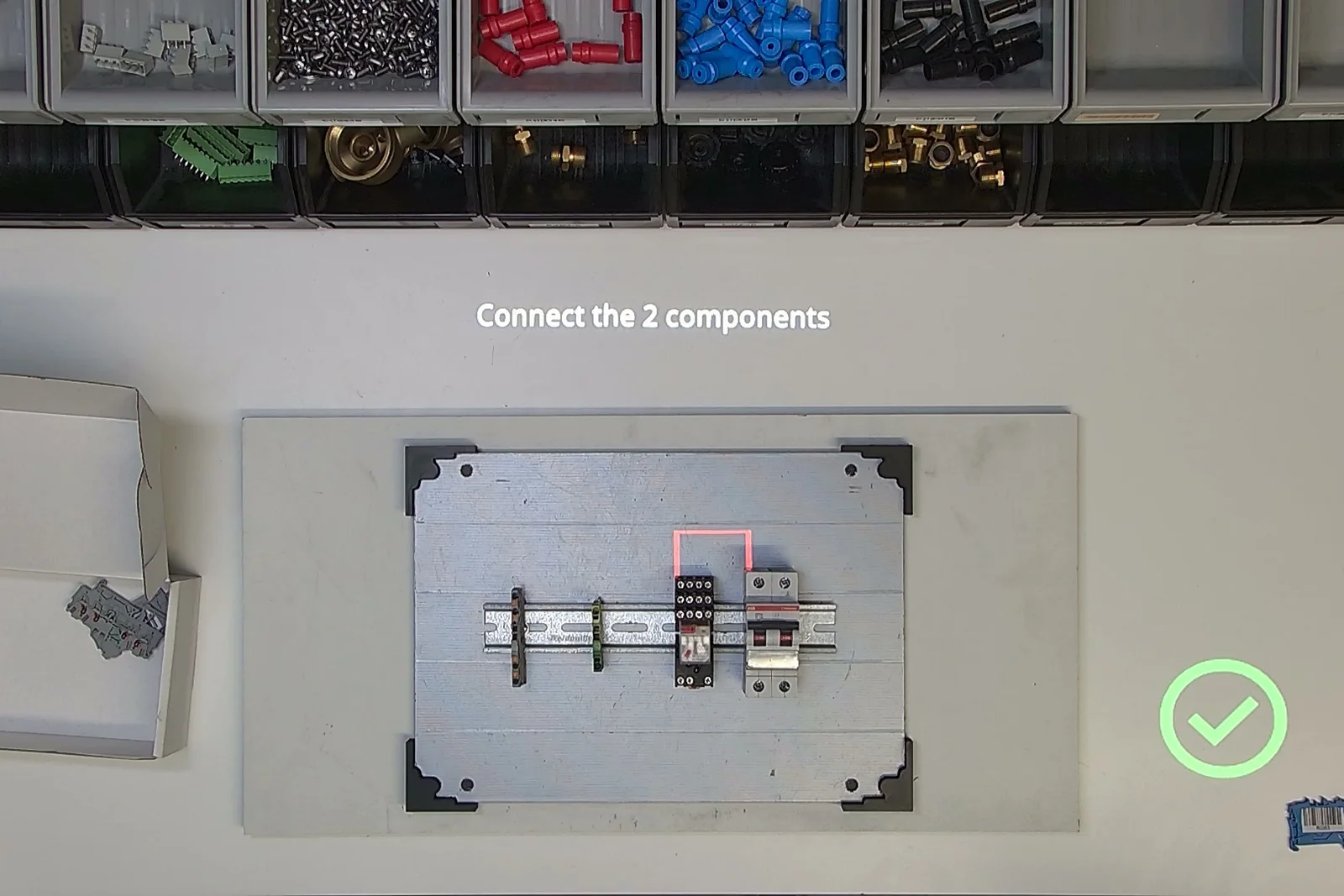 The connection between two components is highlighted with a projected outline while the operator wires the cabinet