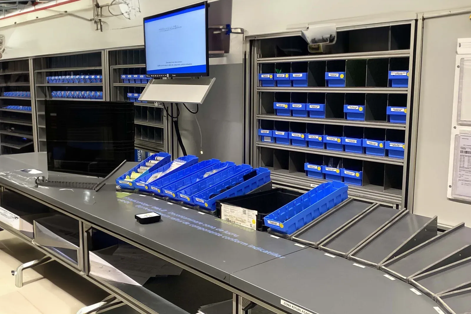 Pick and label station in an aftermarket kitting centre, with an Arkite projector above the packing area